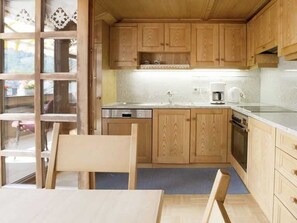 A kitchen with wooden cabinets, a sink, a dishwasher, and a stove.