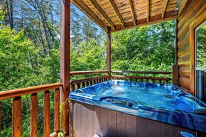 Relax in a serene hot tub on a deck surrounded by lush greenery.