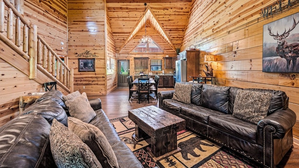 A log cabin interior with a living room, dining area, and kitchen. - Summer Offer • 5 King Suites • Games • Pool Access (Sevierville)