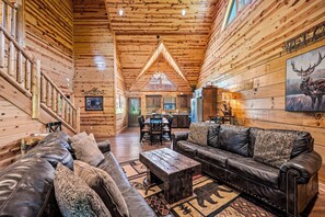 A log cabin interior with a living room, dining area, and kitchen. - Beautiful Cabin • 5 King Suites • Games • Pool Access (Sevierville)