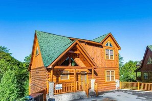 Stylish log cabin with a central entrance and two windows, set amidst a serene natural backdrop.