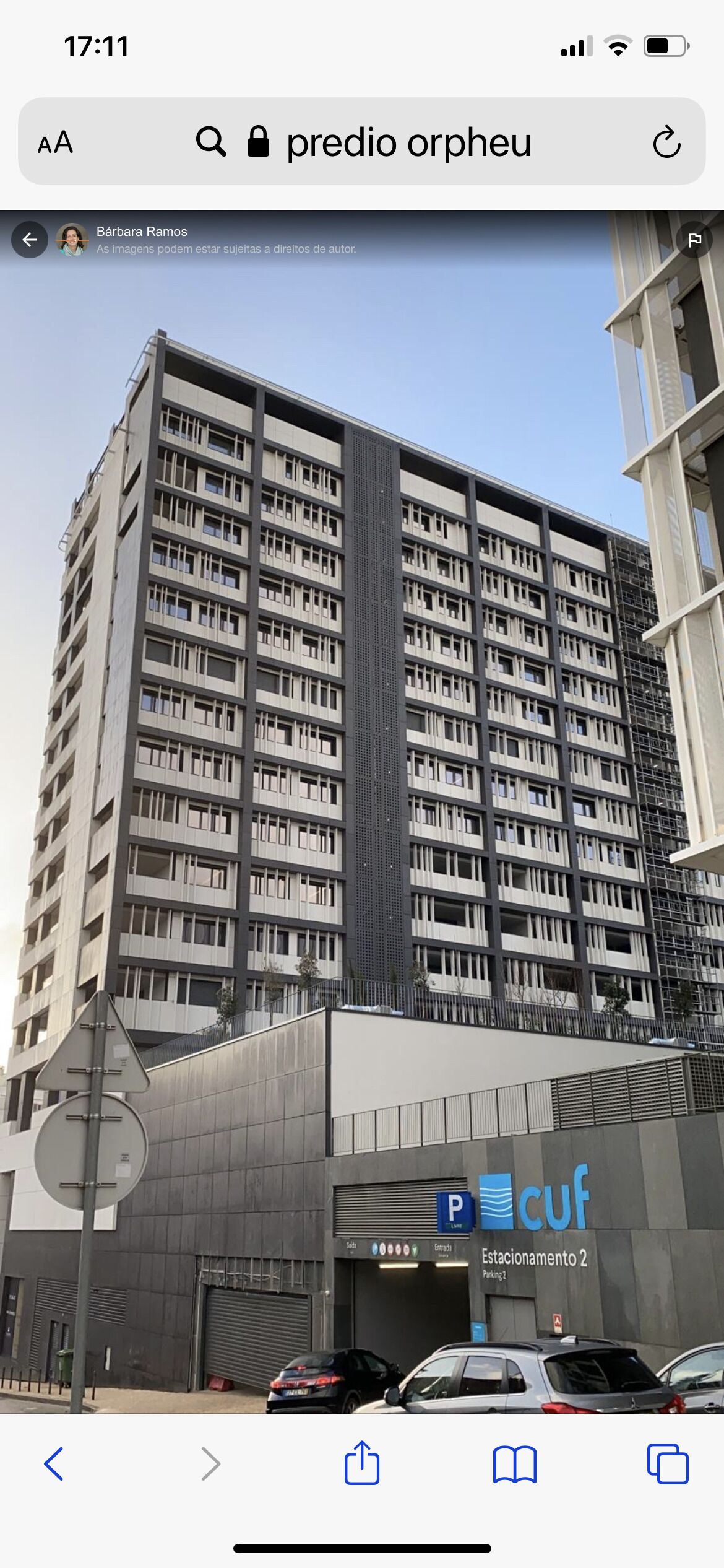 A multi-story building with a modern architectural design, featuring a prominent facade and a parking area labeled "Estacionamento 2".