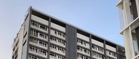 A multi-story building with a modern architectural design, featuring a prominent facade and a parking area labeled "Estacionamento 2".