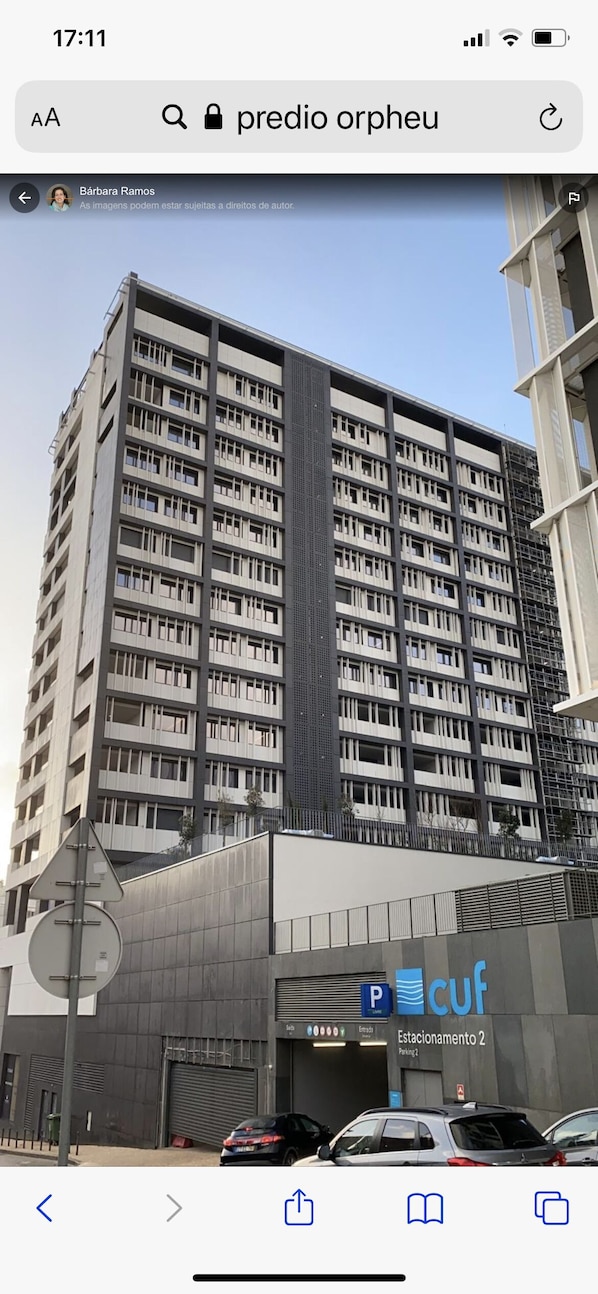 A multi-story building with a modern architectural design, featuring a prominent facade and a parking area labeled "Estacionamento 2".