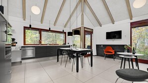 A modern kitchen with a dining area, large windows, and a TV mounted on the wall. - Gorgeous home in Grenaa with kitchen (Grenaa)