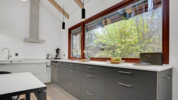 A modern kitchen with a large window, a coffee machine, and a dining area with a table. - Gorgeous home in Grenaa with kitchen (Grenaa)