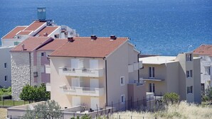 A coastal residential area with multi-story buildings featuring balconies and a view of the sea. - Amazing apartment in Podstrana with WiFi (Podstrana)