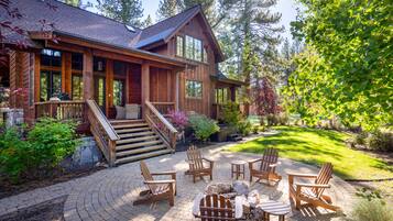 Une cabane en bois dotée d’un patio couvert, comprenant des fauteuils Adirondack et un foyer.