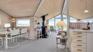 Una cocina moderna con una isla grande, techo de madera y ventanas amplias que ofrecen vistas.