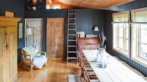 A rustic room with wooden floors, a wooden table, a ladder, and a large window. - Nice home in Sjusjøen with WiFi (Sjusjøen)