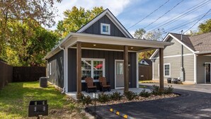 A two-story building with a covered porch and a small outdoor seating area.