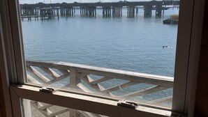 A wooden deck with a view of a bridge over water.