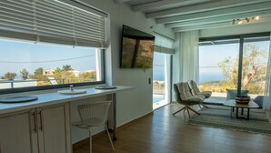 A modern kitchen with a large window, a dining area with a table and chairs, and a view of the outdoors. - Eliandreia Luxury Villa (Lefkada)