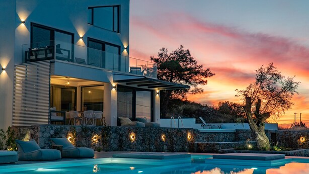 A modern two-story house with a swimming pool, stone walls, and outdoor seating. - Eliandreia Luxury Villa (Lefkada)