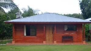 A small wooden cabin with a corrugated metal roof, a wooden door, and a bench outside. - Don Beto House (Provincia de Puntarenas)