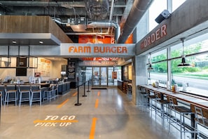 Enjoy a meal at Farm Burger, where a high ceiling and open layout create a spacious dining atmosphere.