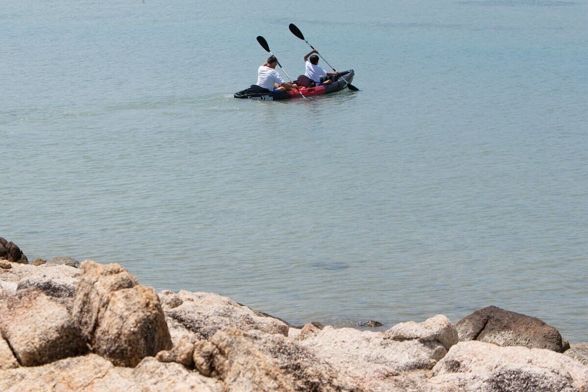 Deux personnes pratiquent le kayak sur une étendue d’eau calme.