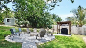 A circular patio with outdoor furniture, a fire pit, and a covered grill area. - Driftwood Way~ No Checkout Chores (Jensen Beach)