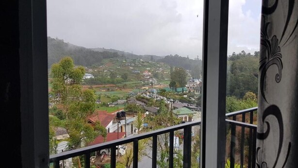 A view from a balcony overlooking a rural landscape with houses and fields. - Hotel Coldworld (Nuwara Eliya)