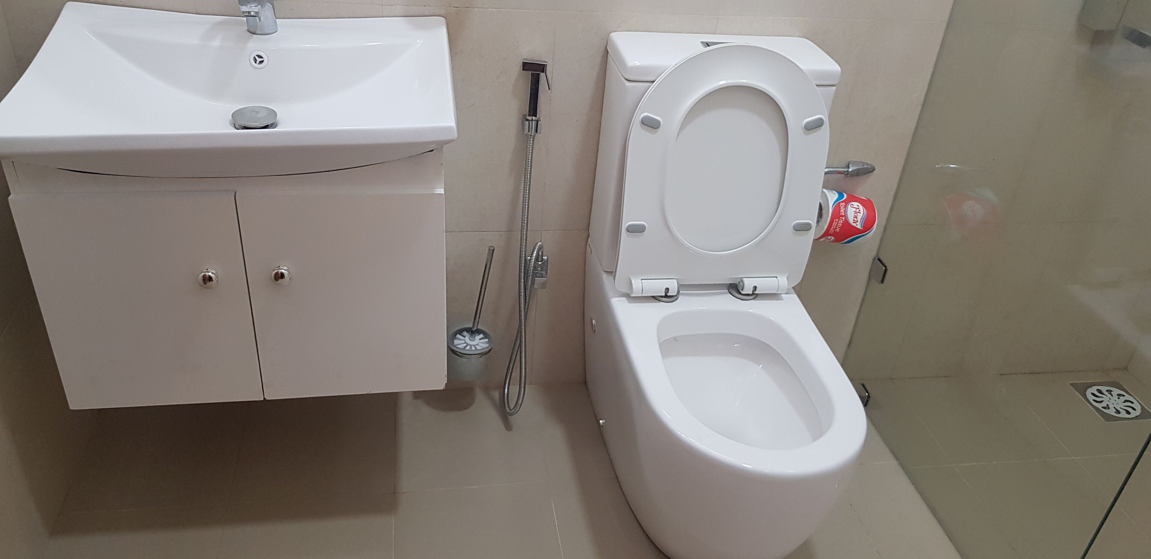 A bathroom with a white sink, toilet, and shower.