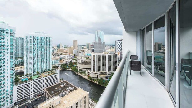Un edificio alto con vista a un paisaje urbano, incluyendo un río y varios edificios.