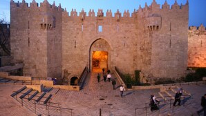 Un gran castillo de piedra con un arco central y escalones que conducen a él.