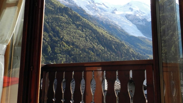 A mountain landscape with snow-capped peaks and dense forest.