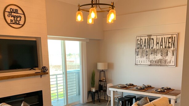 Amplia sala de estar con chimenea, dos sofás, una mesa de centro y un comedor con mesa y sillas.