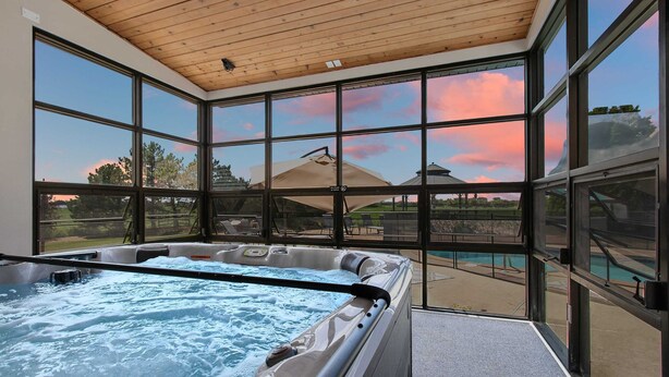 A hot tub with a view of a pool and mountains through large windows. - Sleeps 30 |  Crew-Friendly | Pool & Hot Tub (Appleton)
