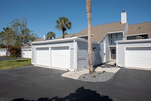 A two-story residential building with a garage, a small tree, and a clear sky. - Deer Run 9767 by Distinctive Beach Rentals (Ponte Vedra Beach)