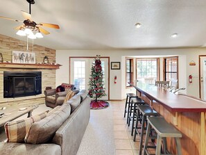 Cozy up by the fireplace in this stylish living area, featuring a comfortable sectional sofa and a beautifully decorated tree.