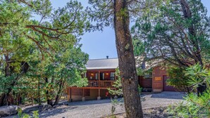Un chalet avec une façade en bois, une véranda et une allée gravillonnée.