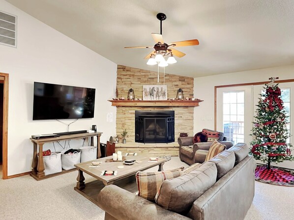 Cozy living room with a fireplace, flat-screen TV, and comfortable sofa.