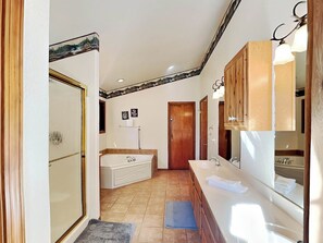 Bathroom features a bathtub, double sink vanity, and wooden cabinet.