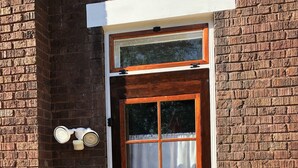 A wooden door with a white frame and glass panels, set in a brick wall. - Vintage Oakley Home (Cincinnati)