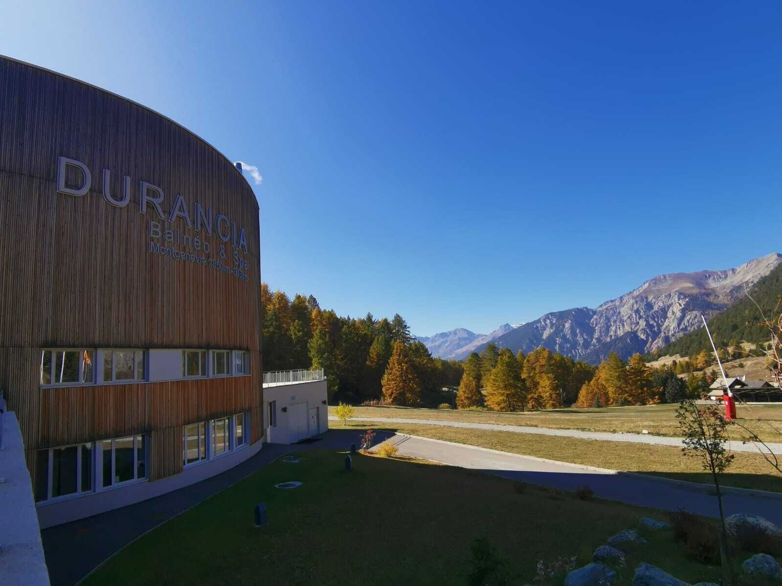 A modern building with a wooden facade and a sign reading "DURANCIA Balneo & Spa".