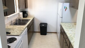 A compact kitchen with a sink, stove, and refrigerator. - Morning Coffee with the quail.  Great views, excellent trails, and work friendly (Grand Junction)