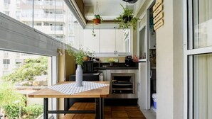 Eine moderne Küche mit einem Holztisch, einem eingebauten Backofen und hängenden Pflanzen.