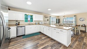 A modern kitchen with white cabinets, a wooden countertop, and a central island. - 🏖 3 Min Walk to the Beach 💦 Ice Machine  🌼 In Quiet Fort Morgan (Gulf Shores)