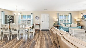 A spacious living area with a dining table and chairs, a sofa, and a coffee table. - 🏖 3 Min Walk to the Beach 💦 Ice Machine  🌼 In Quiet Fort Morgan (Gulf Shores)