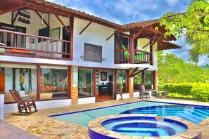 A two-story building with a swimming pool, outdoor seating, and a sign indicating a restaurant. - Beautifull villa with private pool in Quindio (Quimbaya/ quindio / colombia)