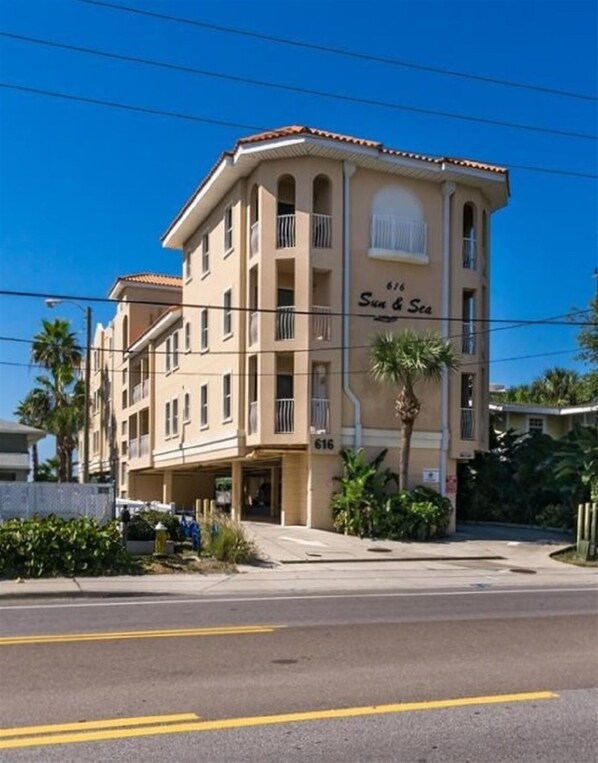 Un hotel de varios pisos con fachada color crema, número 616, y un letrero que dice "Sun & Sea".