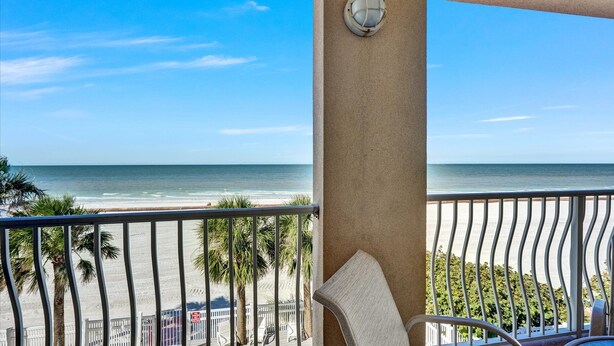 Un balcon avec vue sur la plage et l’océan.