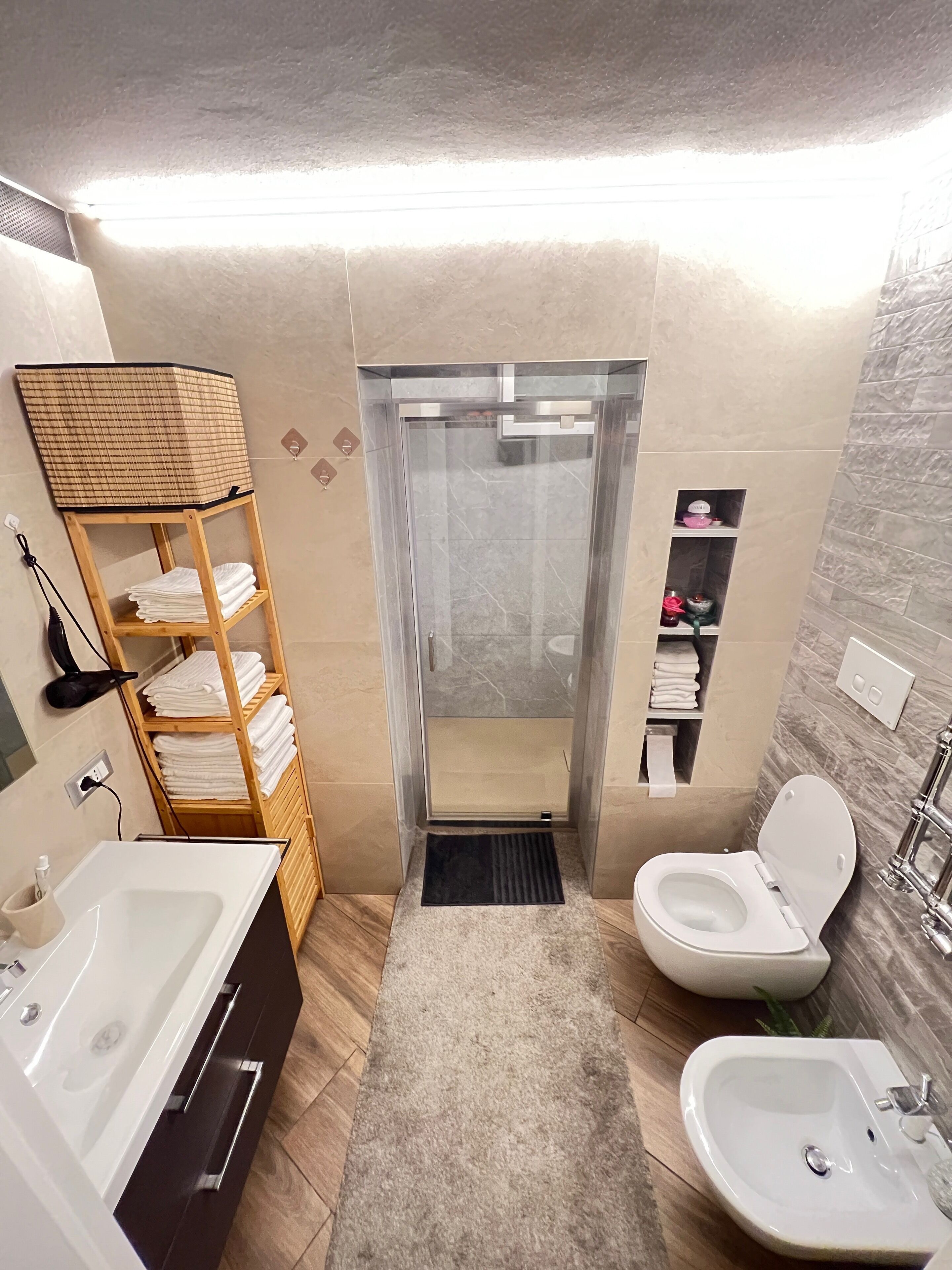 Een moderne badkamer met een bad, een wastafel, een toilet en een douchecabine.