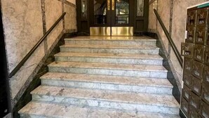 A marble staircase with a metal railing leading to a door with glass panels. - Historic 2BR Apt in ❤️ of DT Seattle Free Parking+ (Seattle)