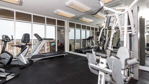 A gym with various exercise machines, large windows, and a view of the outside. - Exceptional Luxury Gulf-Front Condo at Summer Place! (Fort Walton Beach)