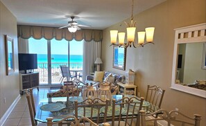 Enjoy ocean views from the large window in this stylish living room, featuring a dining table, comfortable sofa, and TV.