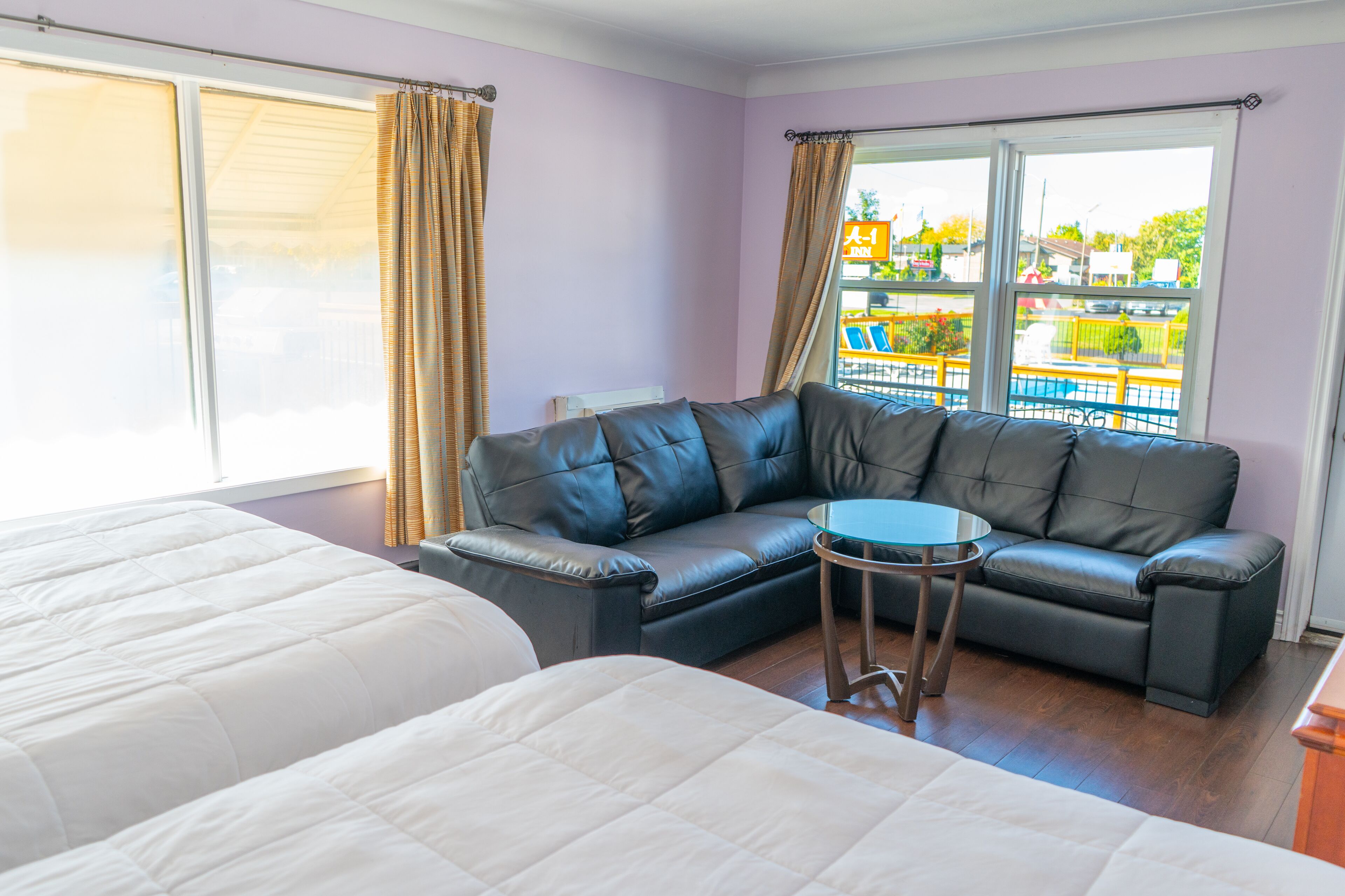 A room with two beds, a sofa, and a small table.
