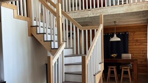 A staircase with wooden railings leading to an upper level. - Echo Lake Lakefront Cabin in picturesque Qu’Appelle Valley,  (Fort san)