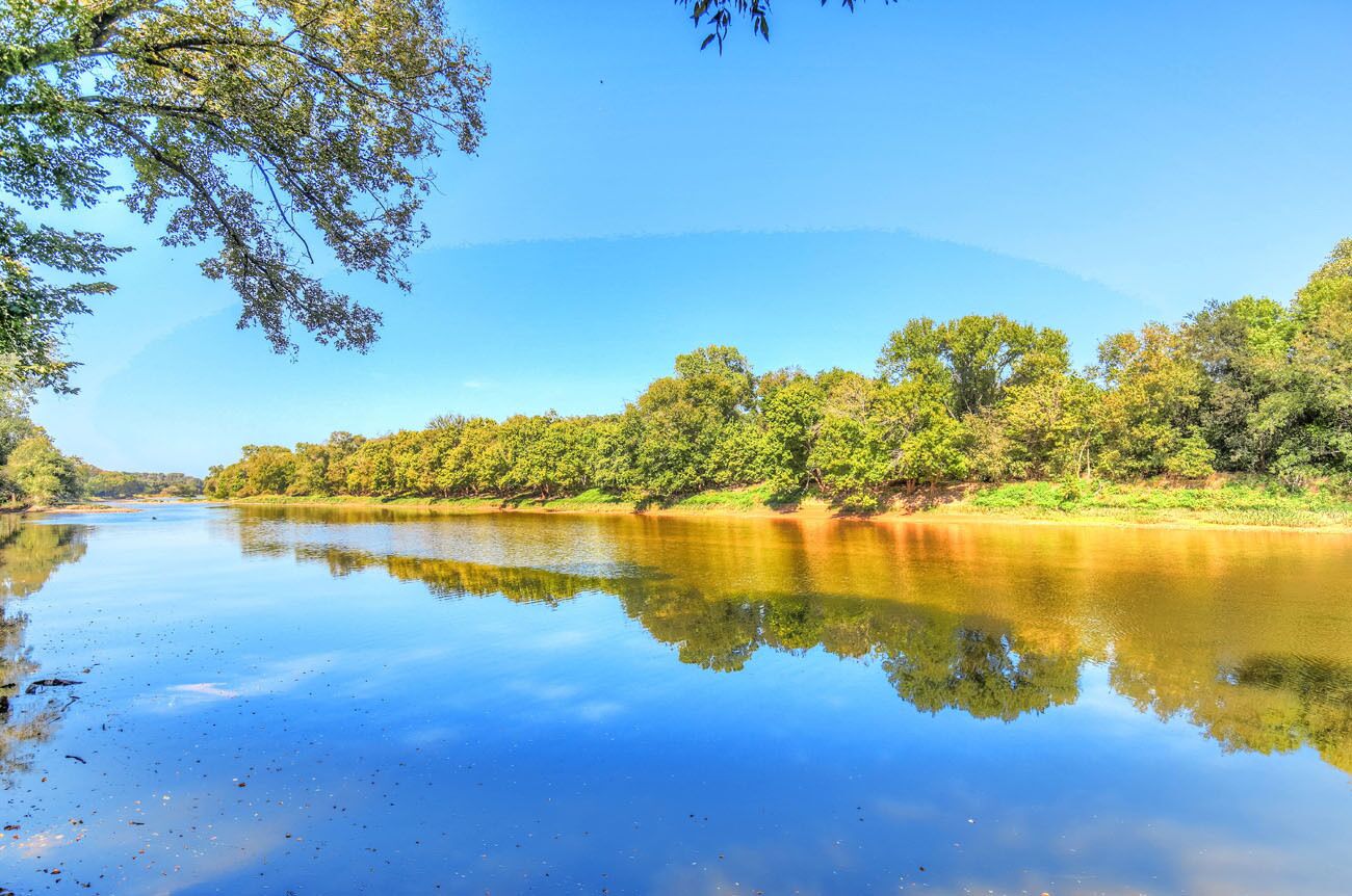A calm river with dense greenery on both sides.